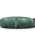 A LAST CHANCE: La Maman Wedge - Navy Night Falls featuring a tropical leaf pattern with various shades of green, blue, and yellow on a white background. The pillow has a small black tag on one side, offers lumbar support.